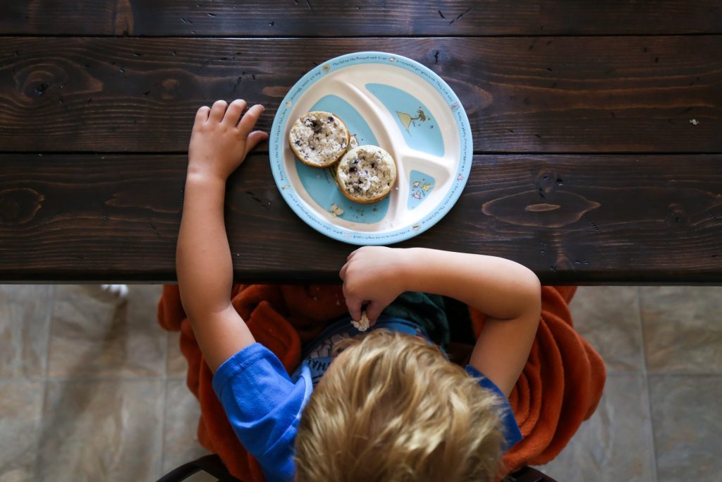 high angle view of boy eating bread while sitting on table at home