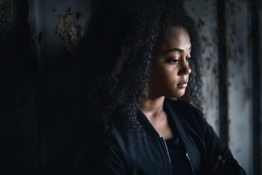 Child Sexual Exploration, Portrait of sad mixed race teenager girl standing indoors in abandoned building.