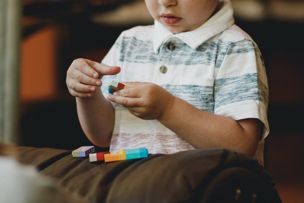 Autism Awareness, child playing with lego blocks.