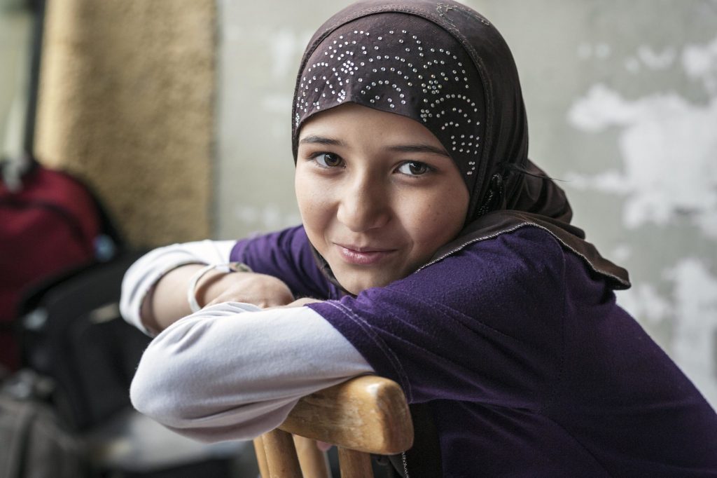 Fostering Asylum Seeking Children, young girl in hijab sitting on chair.