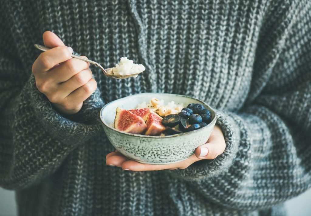 Health Nutrition, person eating bowlful of fruit and berries.
