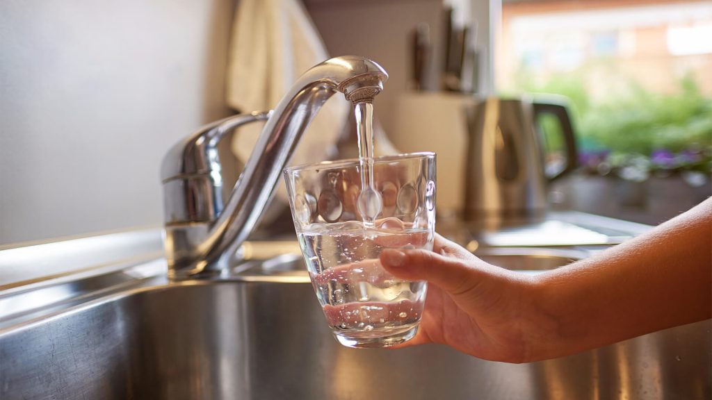 Nutrition Fluids, person filling glass of water from tap.