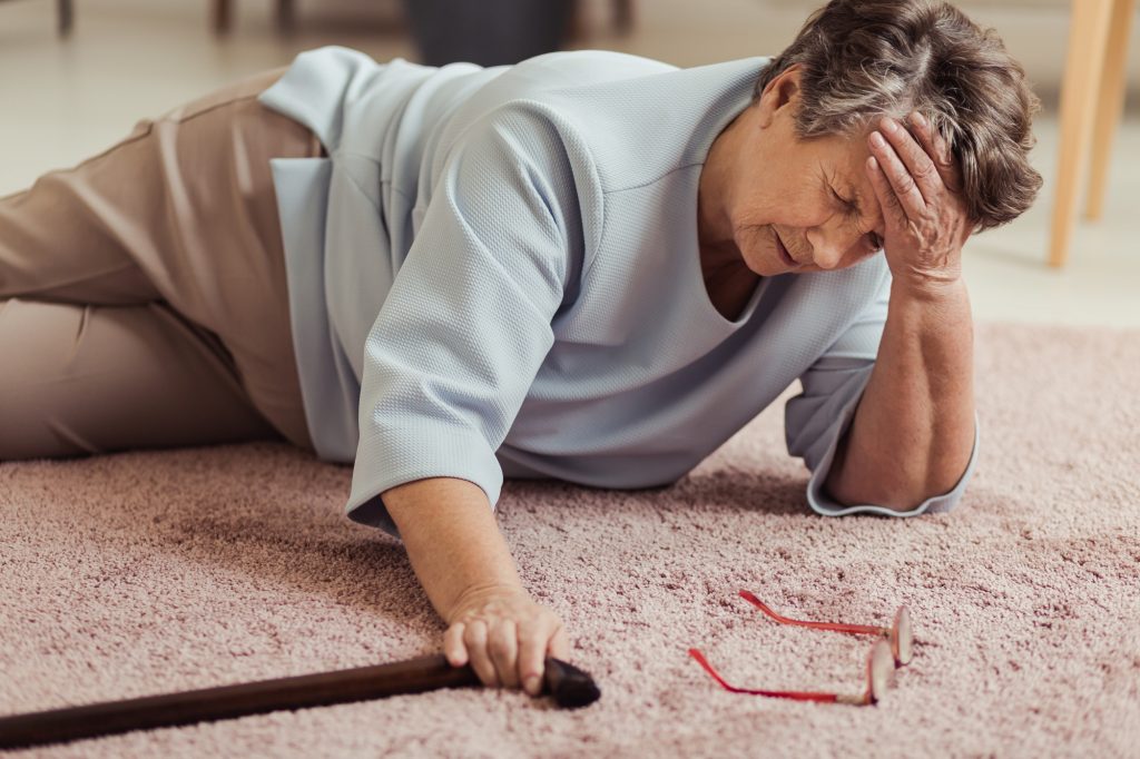 Prevention of falls, elderly woman fallen on floor.