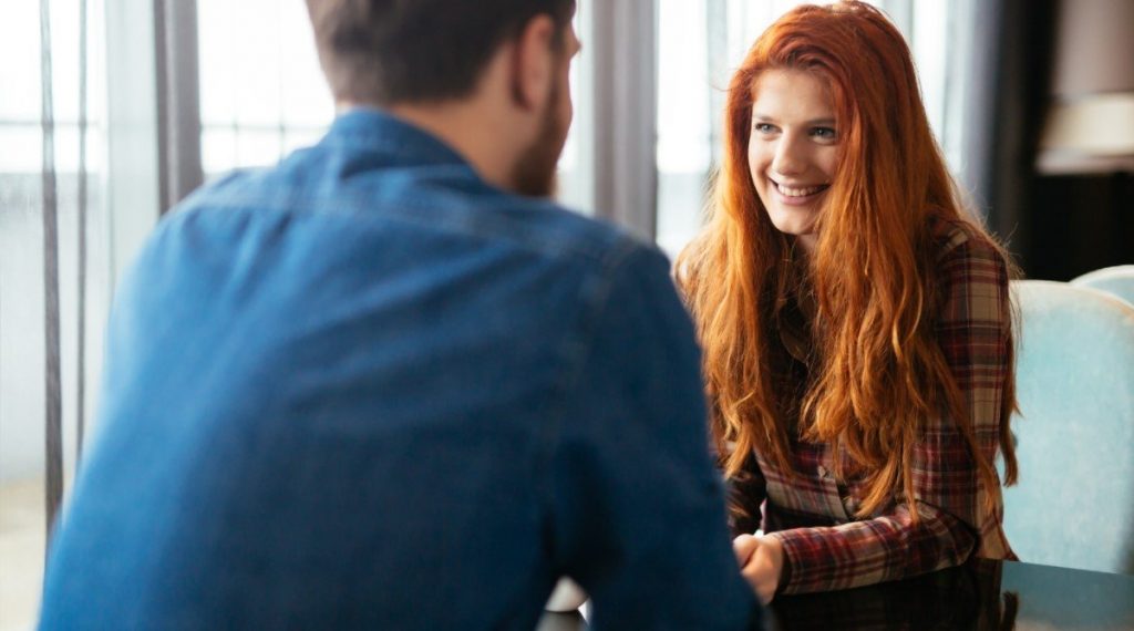 Positive Behavioural Support, young girl looking happy speaking to man.