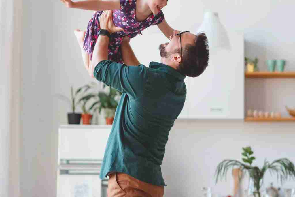 Father lifting child up playing