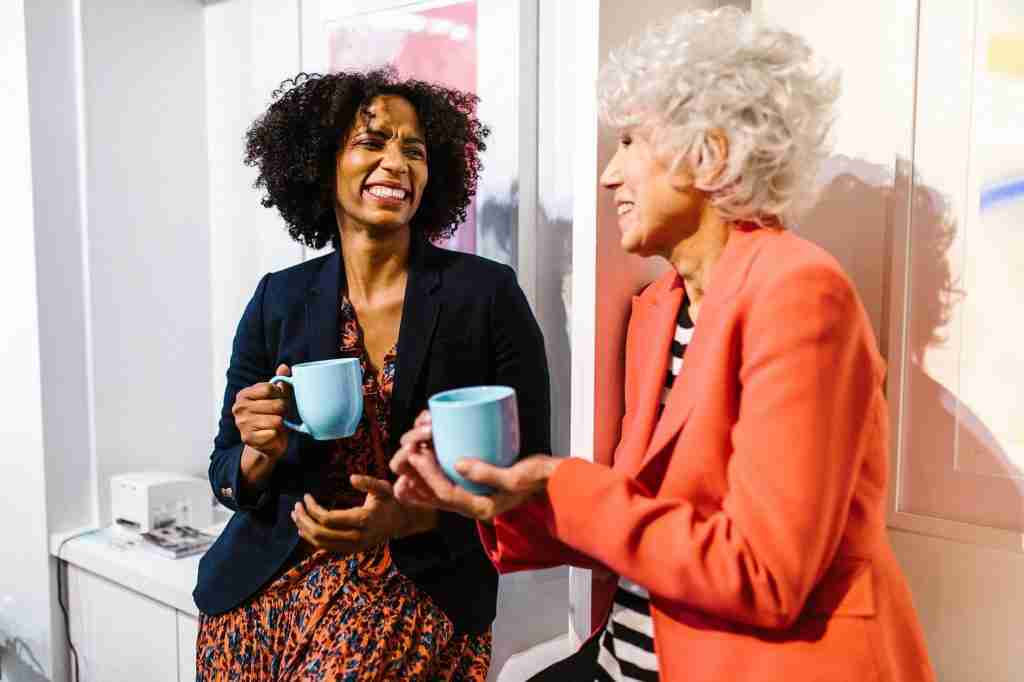 Two women drinking from mugs talking about Menopause. Menopause Awareness Training